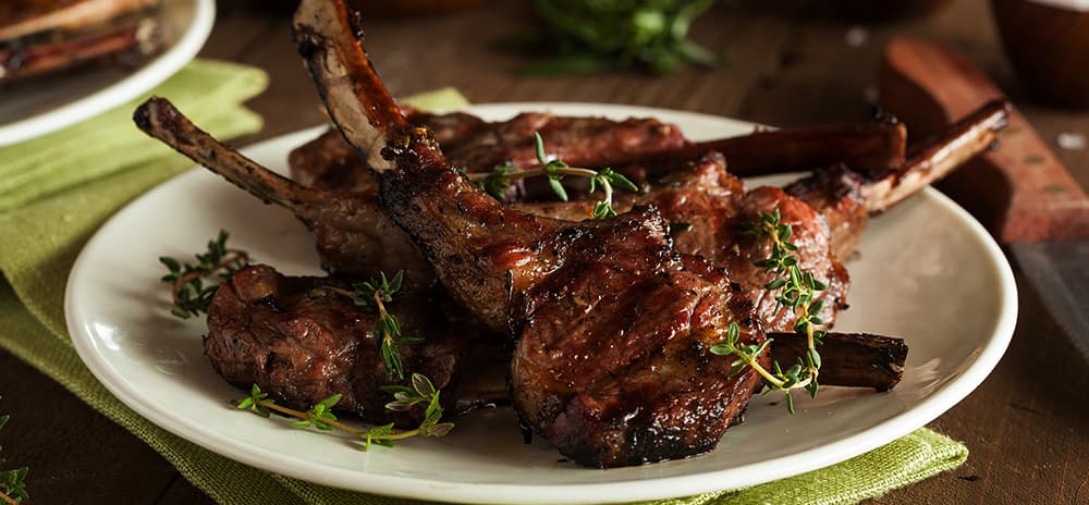 Image is of cooked lamb cutlets on a plate